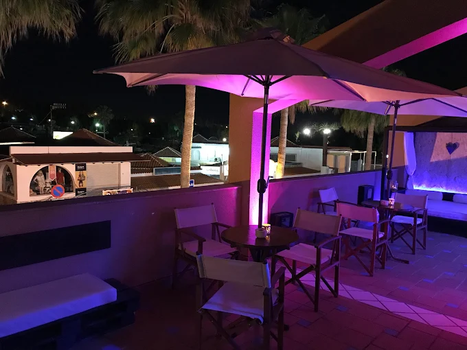 Rincón lounge de DVN Lounge Club, ambiente íntimo con iluminación en tonos rosas
